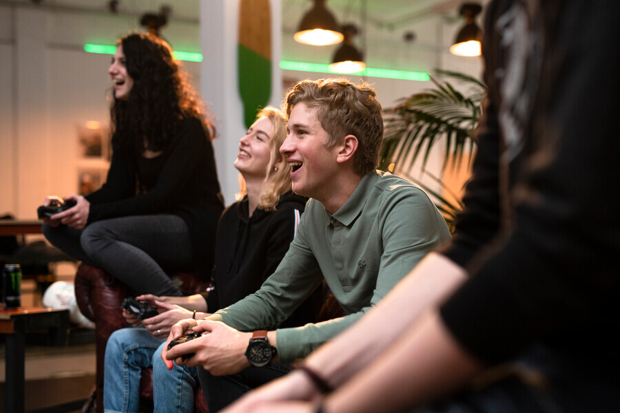 Lachende tieners spelen computerspelletjes