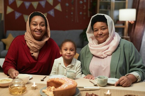 twee vrouwen en een meisje zitten aan tafel